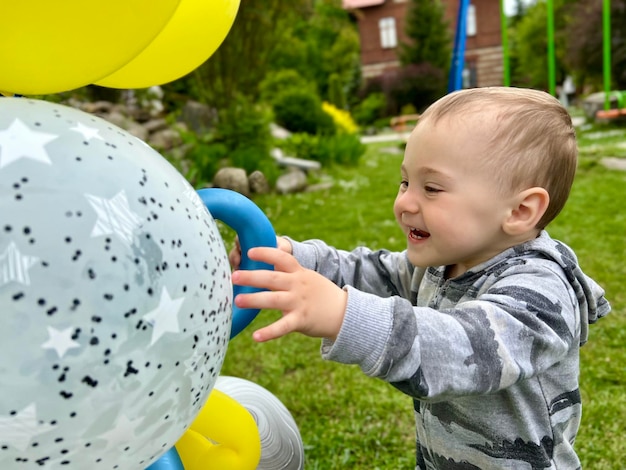 Toddler boy playing with balloons outdoors A cute boy of one and a half years Selective focus