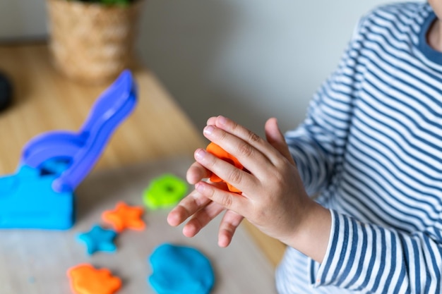 Toddler child playing with modeling compound set at home Kid early development creative play