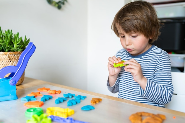 Toddler child playing with modeling compound set at home Kid early development creative play