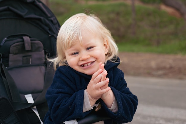 Toddler cute baby boy in a baby carriage