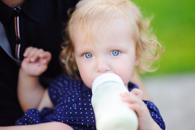 Toddler girl drinking milk from bottle