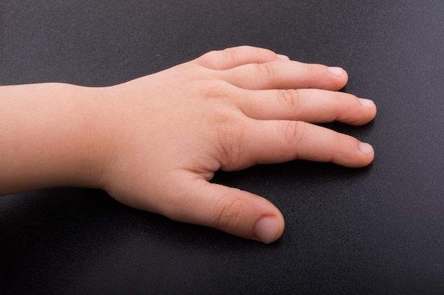 Toddler hand with dark color background