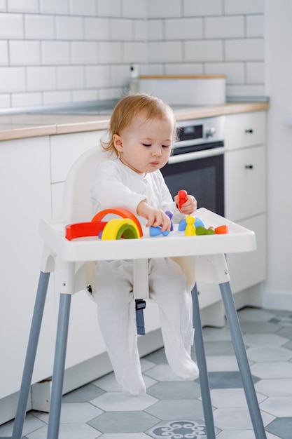 A toddler in highchair playing with a wooden rainbow toy Learning colors Development New skills