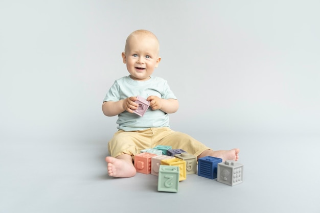 Toddler playing with silicone pastel colored cubes blocks Montessori material for fine motor skills sensory play Copy space