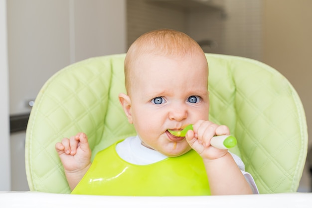 toddler sitting in a high chair and eats