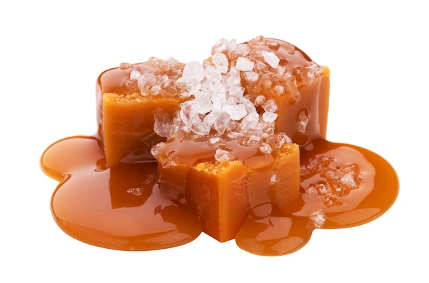 Toffee candies with melted caramel sauce and salt isolated on white