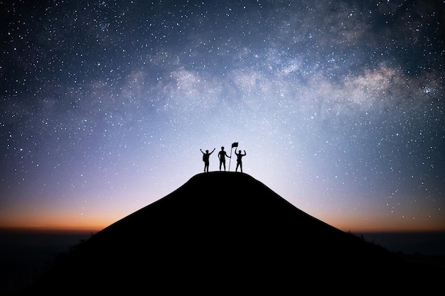 Together overcoming obstacles as a group of three people raising hands up and holding flag.