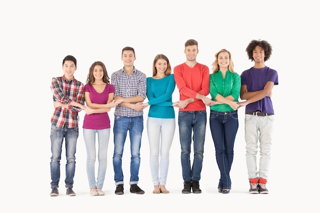 Together we are strong. Full length of cheerful multi-ethnic people holding hands while standing in a row