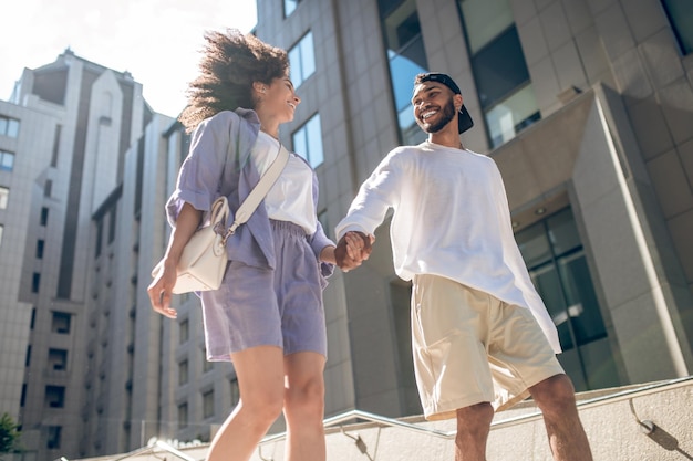 Togetherness. Young couple walking in the street and holding hands