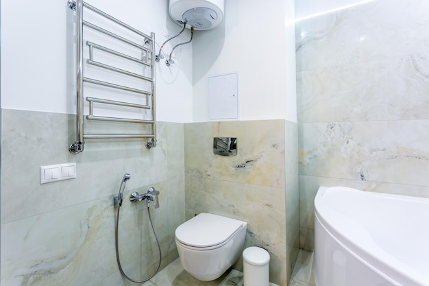 Toilet and detail of a corner shower bidet with soap and shampoo dispensers on wall mount shower attachment