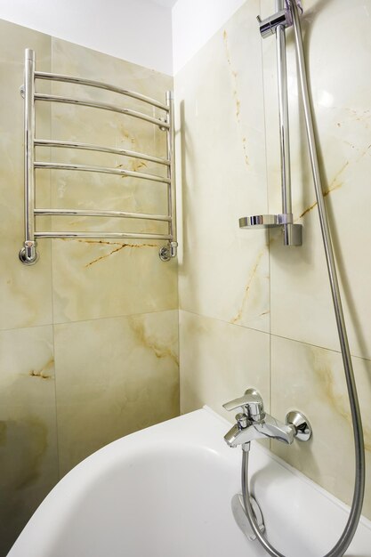 Toilet and detail of a corner shower cabin with wall mount shower attachment in bathroom of hotel