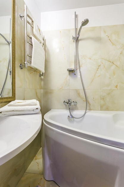 Toilet and detail of a corner shower cabin with wall mount shower attachment st bathroom of hotel