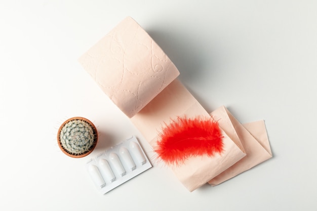 Toilet paper, feather, cactus and candles on white, top view