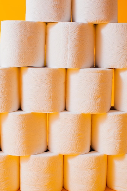 Toilet paper rolls as a wall background pattern over yellow