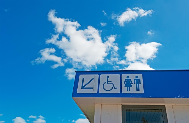 Toilet sign under a cloudy sky