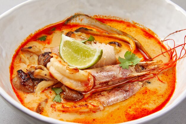 tom yam, shrimp and fish in tomato sauce with herbs and lime, seafood soup