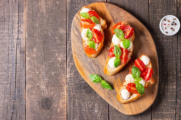 Tomato, basil and cheese fresh made caprese bruschetta. Italian tapas, antipasti with vegetables, he