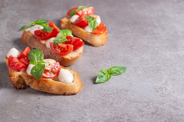 Tomato, basil and cheese fresh made caprese bruschetta. Italian tapas, antipasti with vegetables, he