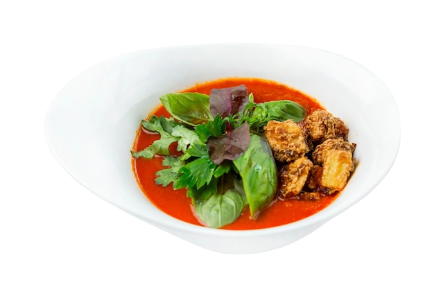 Tomato cream soup with basil leaves and croutons Appetizing popular traditional Mediterranean dish Closeup Isolated on white background