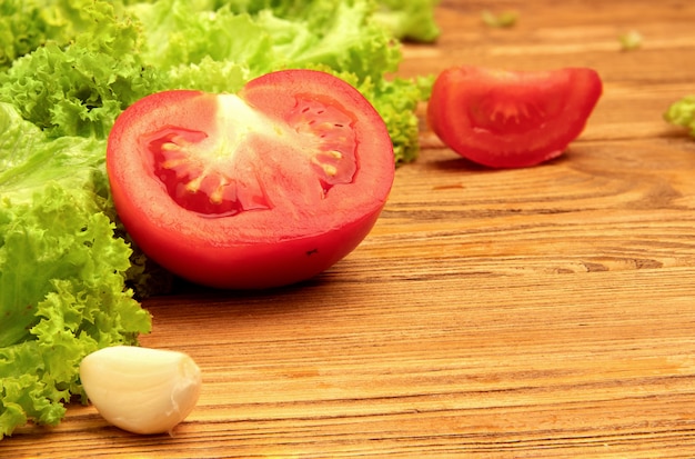 Tomato, garlic and lettuce on a wooden table