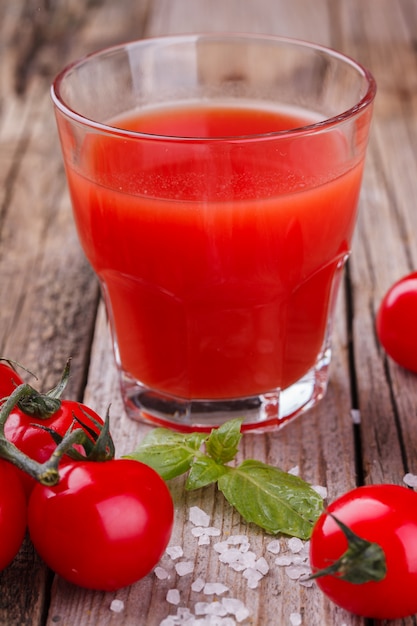 Tomato juice in a glass beaker. Vine tomatoes and Basil