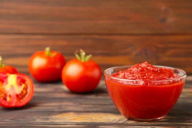 Tomato ketchup sauce in a bowl with tomatoes