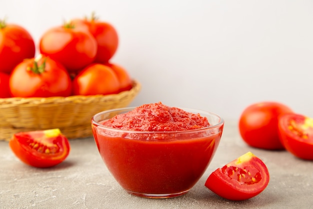 Tomato ketchup sauce in a bowl with tomatoes