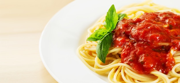 Tomato pasta served on plate with basil 