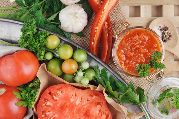 Tomato sauce and ingredients for its cooking on metal dish. Top view.