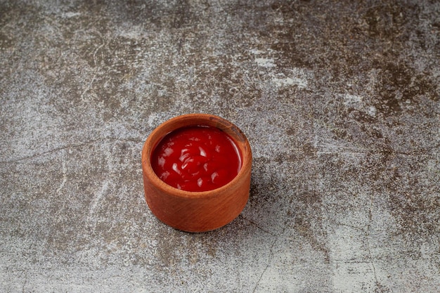 Tomato sauce in a sauce pot on a restaurant stone table