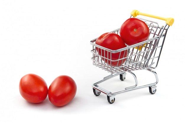 A tomato in shopping cart isolated on white background. Ripe tasty red tomatos in shopping cart. Tomato trading concept. Online shopping concept. Cart and tomato over a white background.