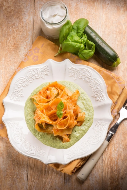 Tomato tagliatelle over zucchinis pesto sauce