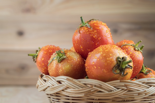 tomatoes in basket on wooden table