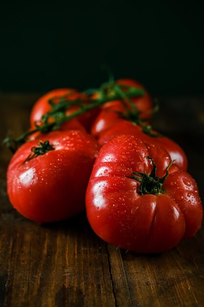 Tomatoes on a branch Fresh tomatoes on a wooden table Azeybarjan tomatoes Ripe tomatoes