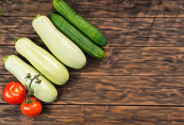 Tomatoes, cucumbers and squash on wooden boards