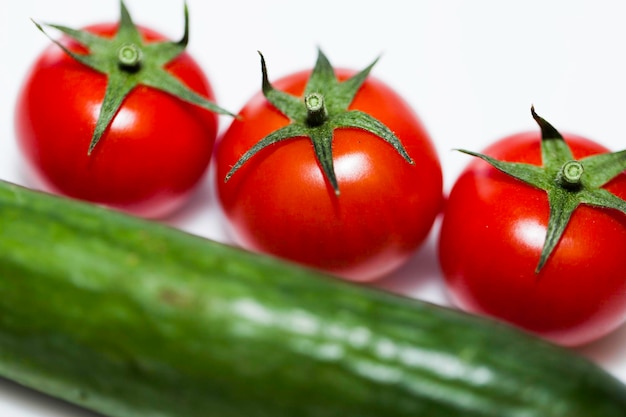 tomatoes and cucumbers on white background