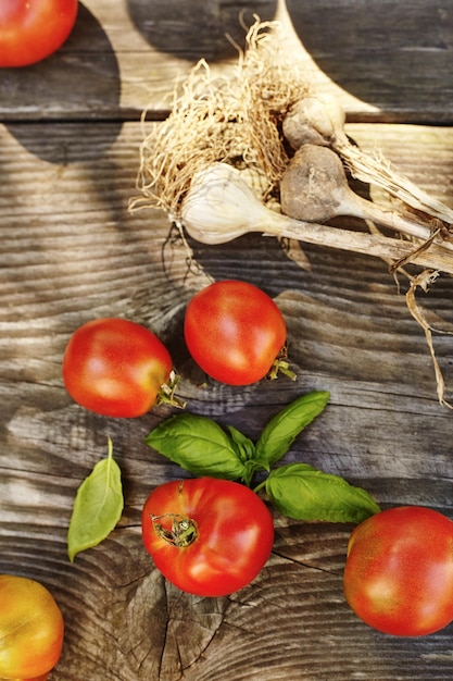 Tomatoes, garlic, basil on an old authentic table. Fresh homemade ingredients for pasta