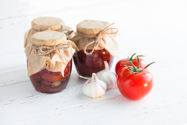 Tomatoes in the jar. Homemade sun dried tomatoes. temporary closing down. Summer and autumn canned food. conserve with spices and vegetables.