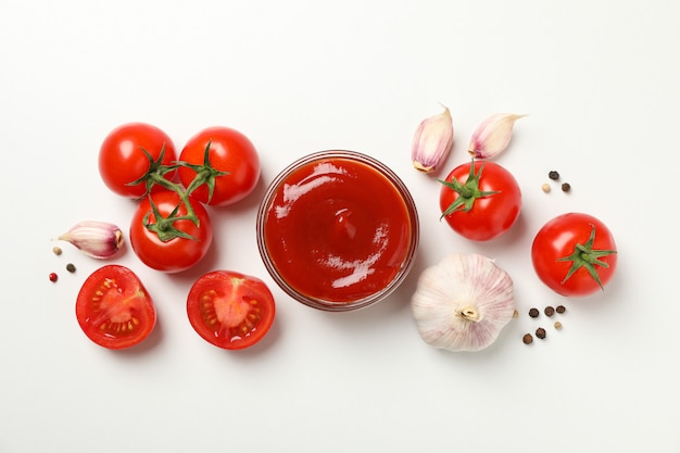 Tomatoes, sauce and ingredients on white background, top view