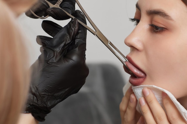 Tongue piercing operation Professional holding the jewel