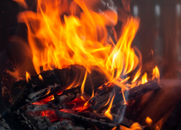 Tongues of red flame of fire behind the glass of the fireplace stove