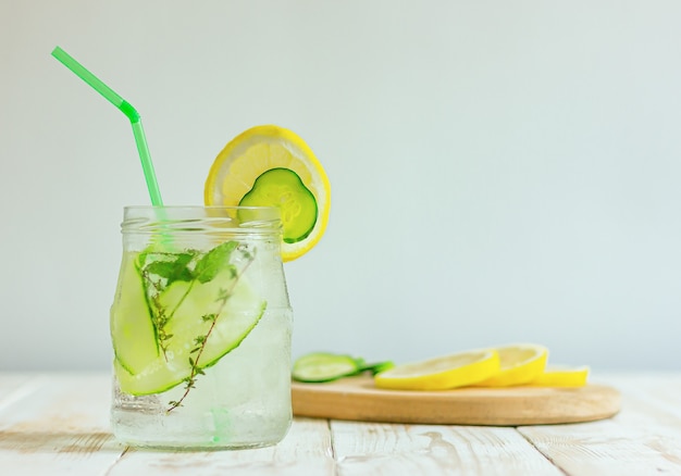 Tonic drink from cucumbers and lemon in a glass jar on a table with a copy space. homemade summer refreshing beverage.