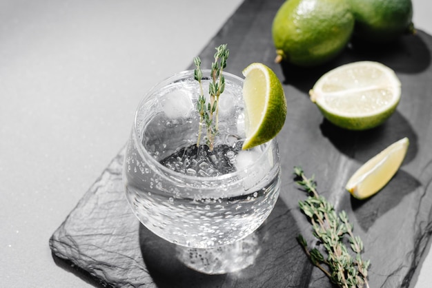 Tonic with lime and thyme cocktail on a gray background flashy food