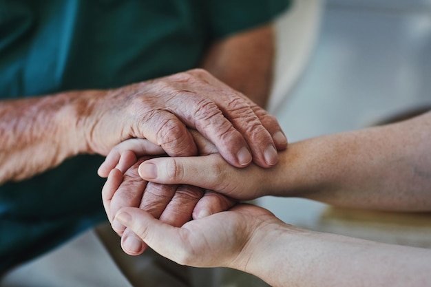 Too often we underestimate the power of a listening ear Closeup shot of a woman holding a senior mans hands in comfort