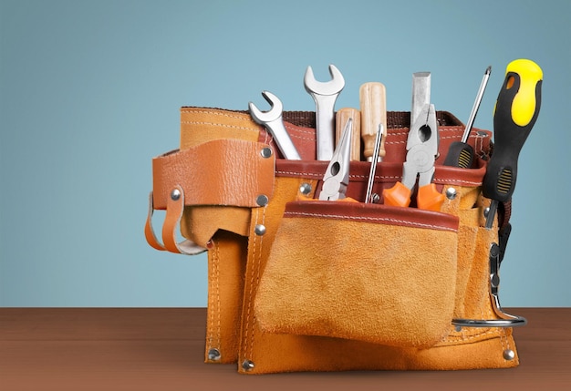 Tool belt with tools on wooden background