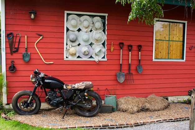 Tools and equipments farm gardening on red wooden wall of barn farmhouse for farmer use growing cultivating horticulture at meadow rural countryside in Nonthaburi Thailand