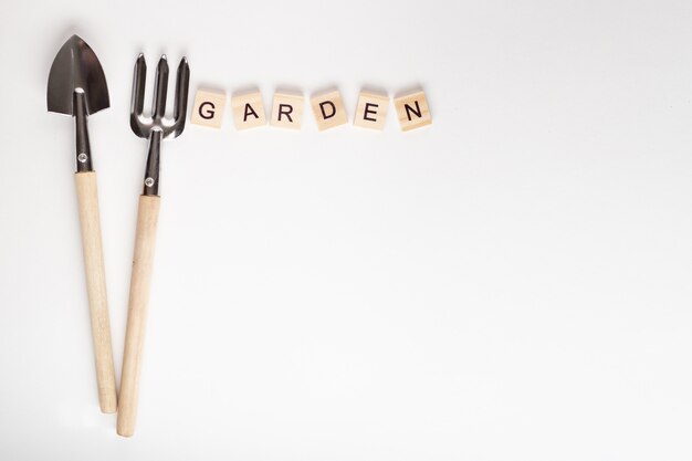 Tools for gardening at home and GARDEN text made of wooden cube