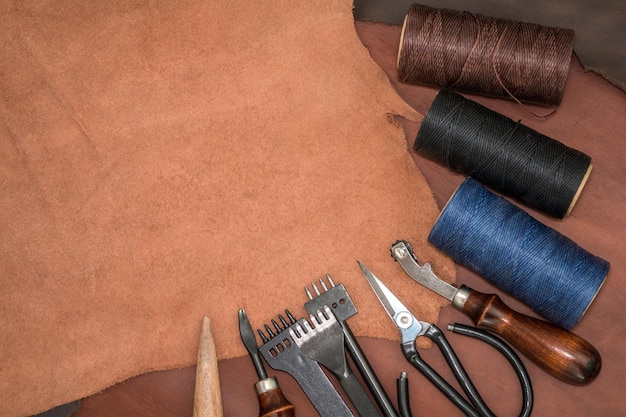 Tools for leather crafting and pieces of brown leather