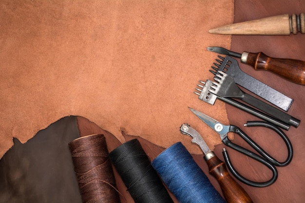 Tools for leather crafting and pieces of brown leather