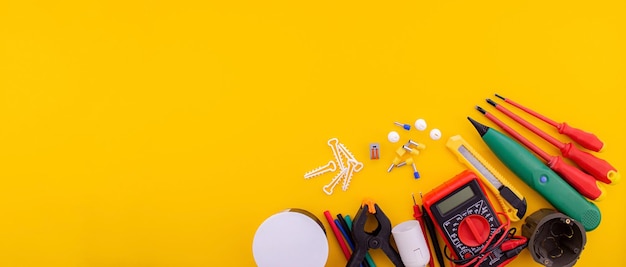 Tools on a yellow background screwdriver tester tracker